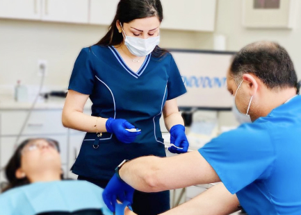 Picture of Dr. Maz Ebrahimi and his assistant working on a patient